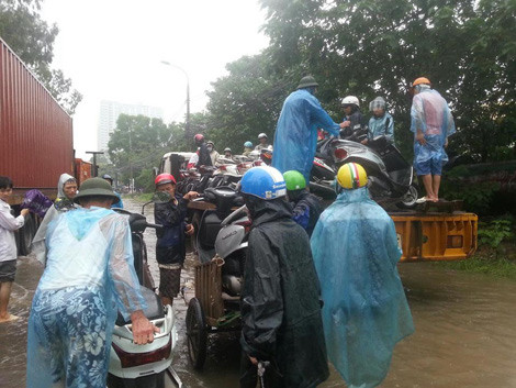 Sáng ngày 9/8, nước vẫn ngập trên đường 70 gần sông Nhuệ. Ảnh: Trang HC