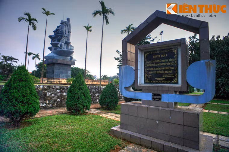 Giữa tượng đài và khu mộ là một tấm bia lớn cách điệu, trên hai mặt bia đều khắc dòng chữ vàng của nhà thơ cách mạng người Pháp Louis Aragon: “Yên Bái, đây là điều nhắc nhở ta rằng không thể bịt miệng một dân tộc mà người ta không khuất phục bằng lưỡi kiếm của đao phủ”.