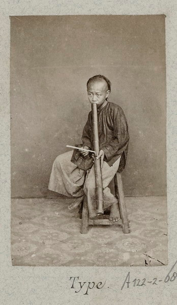 Cậu bé người Hoa hút thuốc bằng ống điếu.