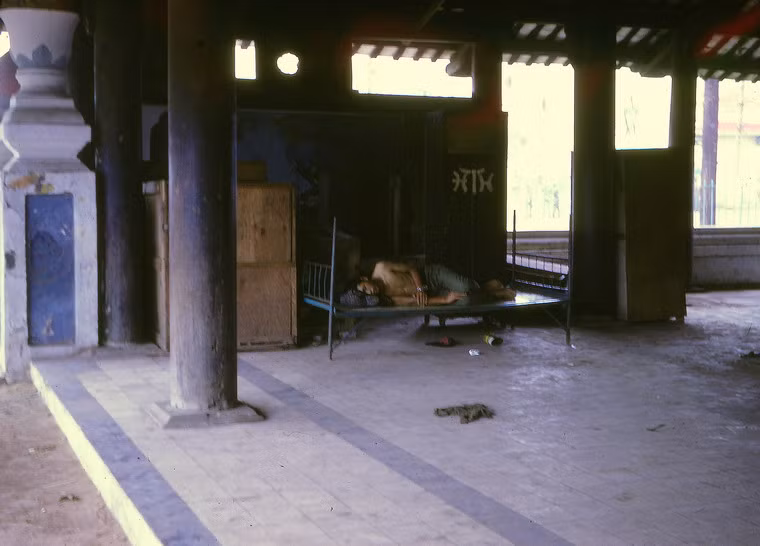 Vào thời VNCH, do sự mở mang đường xá mà diện tích lăng thu hẹp và công trình nằm lọt thỏm trong điểm tròn giữa đường Võ Tánh. Ảnh: Người giữ lăng nằm trên chiếc giường kê ở một góc lăng mộ.