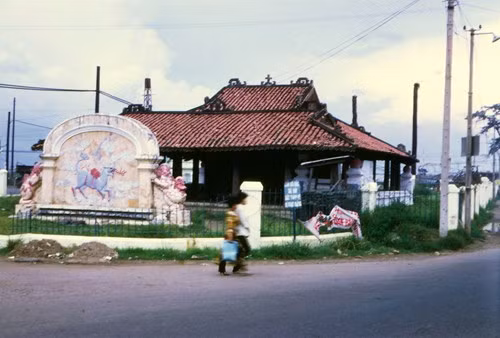 Lăng Cha Cả ngày nay là tên gọi của vòng xoay giao thông, ở giữa đặt quả địa cầu lớn gần sân bay Tân Sơn Nhất, TP HCM. Tên gọi này có nguồn gốc từ việc nơi đây từng tồn tại lăng mộ của giám mục Bá Đa Lộc, tục gọi là "Cha Cả". Ảnh: Toàn cảnh Lăng Cha Cả năm 1970. Hình ảnh do tác giả người Mỹ Frederick P Fellers thực hiện.