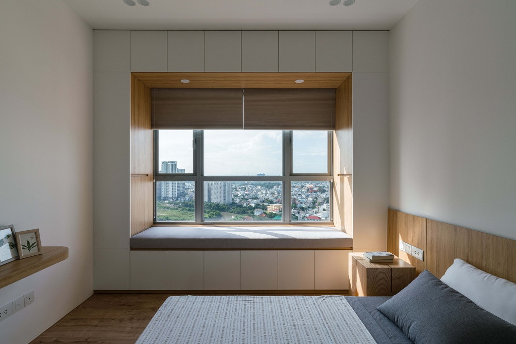 Phòng ngủ được bài trí tối giản, đồ đạc gọn gàng. Phòng của bố mẹ được bố trí thêm khu cửa sổ bay có tủ sách âm hai bên trở thành không gian đệm để chủ nhà thư giãn, ngắm cảnh.