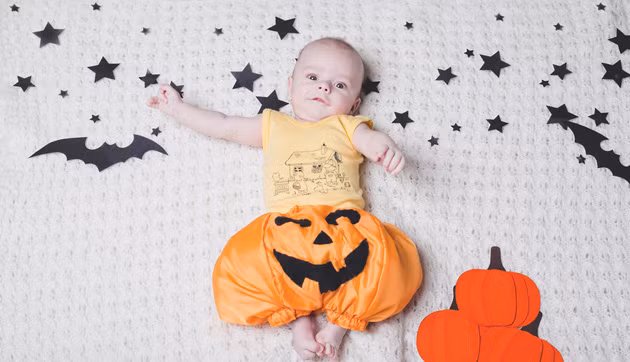 Em bé được hóa trang với chiếc quần bí đỏ cực "cute" đang bay giữa bầu trời huyền bí đầy sao và dơi.