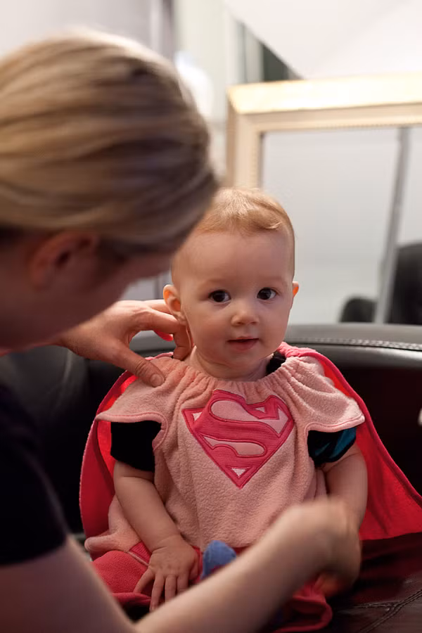 Em bé này được mẹ sắm cho hẳn một bộ "siêu nhân màu hồng" nhé!