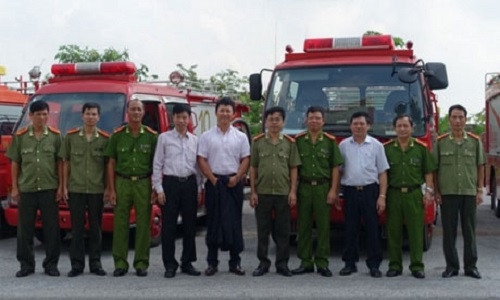 Các đại biểu chụp ảnh bên những chiếc xe cứu hỏa do Nhật Bản tài trợ.