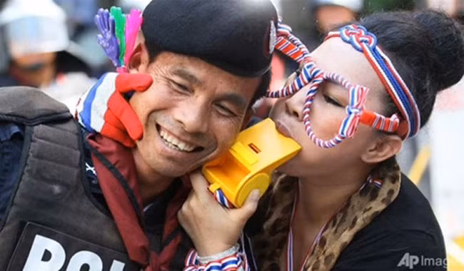 Cử chỉ thân thiện giữa cô gái thuộc phe phản đối chính phủ và nam cảnh sát.