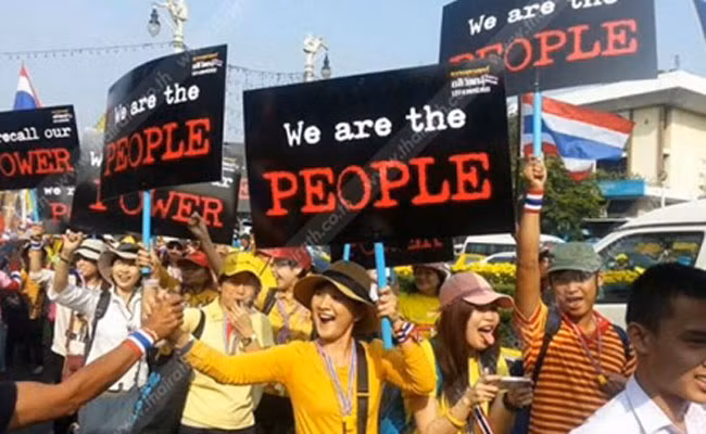 Cô gái thuộc phe áo Vàng tươi cười rạng rỡ hòa chung với dòng người tham gia diễu hành.