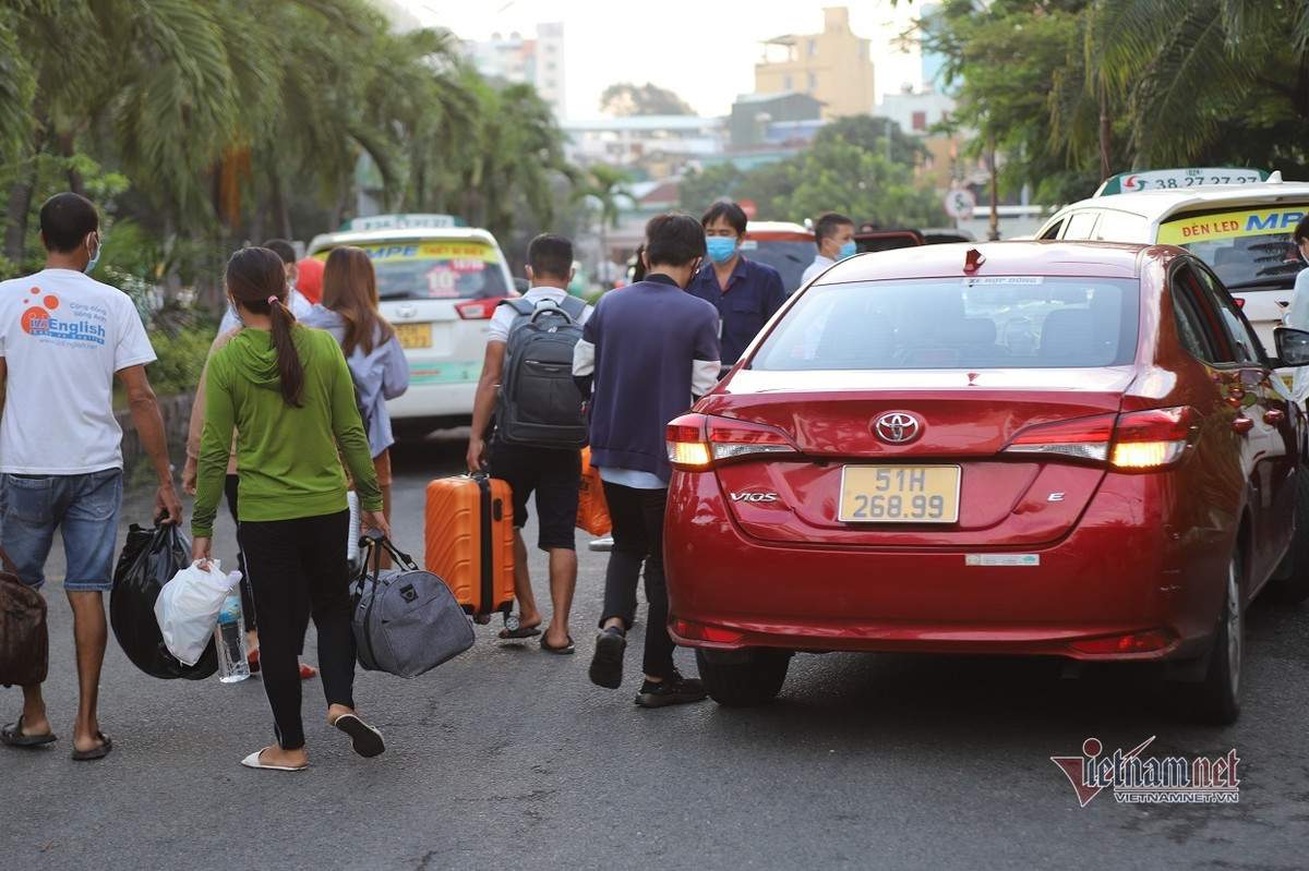 Trong ảnh, hành khách gọi ứng dụng xe công nghệ để về nhà. Tất cả hành khách đến TP.HCM đều không phải cách ly tập trung mà được về nhà và tự theo dõi sức khỏe.