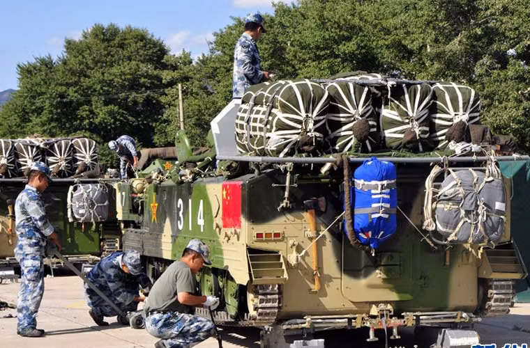 Trong ảnh, binh sĩ Trung Quốc đang chuẩn bị lắp dù “khủng” cho các xe chiến đấu đổ bộ đường không ZLC-2000 chuẩn bị cho cuộc diễn tập đổ bộ lớn từ máy bay Il-76. Trung Quốc là một trong số ít quốc gia sở hữu xe thiết giáp đổ bộ đường không, ZLC-2000 thực chất cũng là bản sao chép công nghệ mẫu xe BMD-3 của Nga.