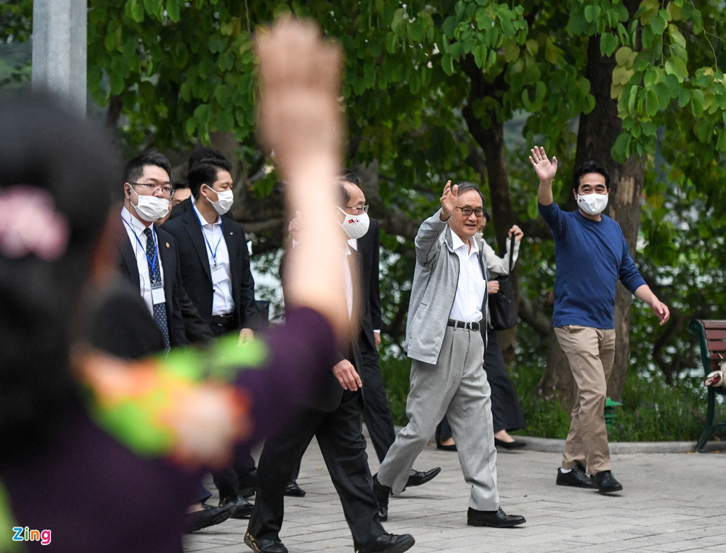 Nhiều người dân Hà Nội bất ngờ khi thấy thủ tướng Nhật xuất hiện. Họ vẫy tay chào và được ông Suga đáp lại.