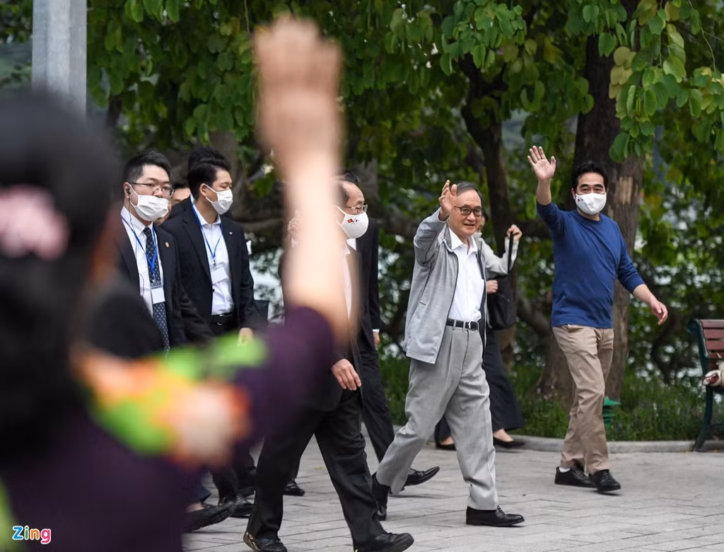 Nhiều người dân Hà Nội bất ngờ khi thấy thủ tướng Nhật xuất hiện. Họ vẫy tay chào và được ông Suga đáp lại.