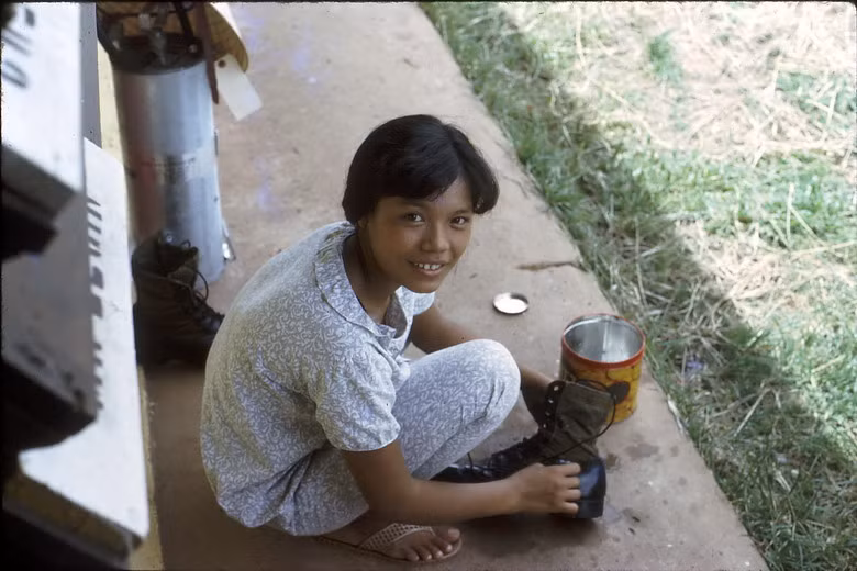 Một phụ nữ Việt đánh giày cho lính Mỹ.