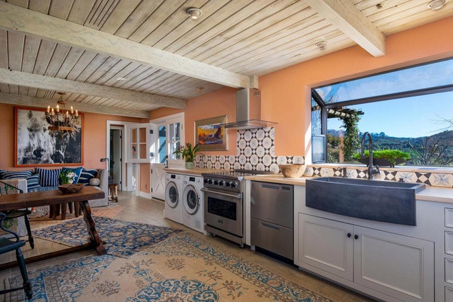 Nhà bếp và khu vực giặt giũ được tích hợp trong một không gian rộng lớn, thông thoáng, tràn ngập ánh sáng tự nhiên, và được tô điểm với những gam màu bắt mắt.