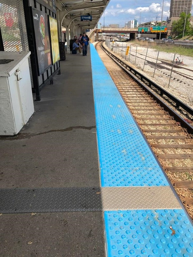 Vạch an toàn màu xanh trước đường ray tàu hoàn toàn nổi bật so với cảnh vật xung quanh.