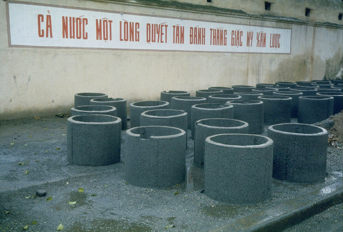 Ống bê tông dùng để xây hố tránh bom cá nhân được tập kết bên vỉa hè, phía trước xưởng sản xuất những chiếc ống này, Hà Nội năm 1967. Ảnh: Lee Lockwood/ Life/ Getty.