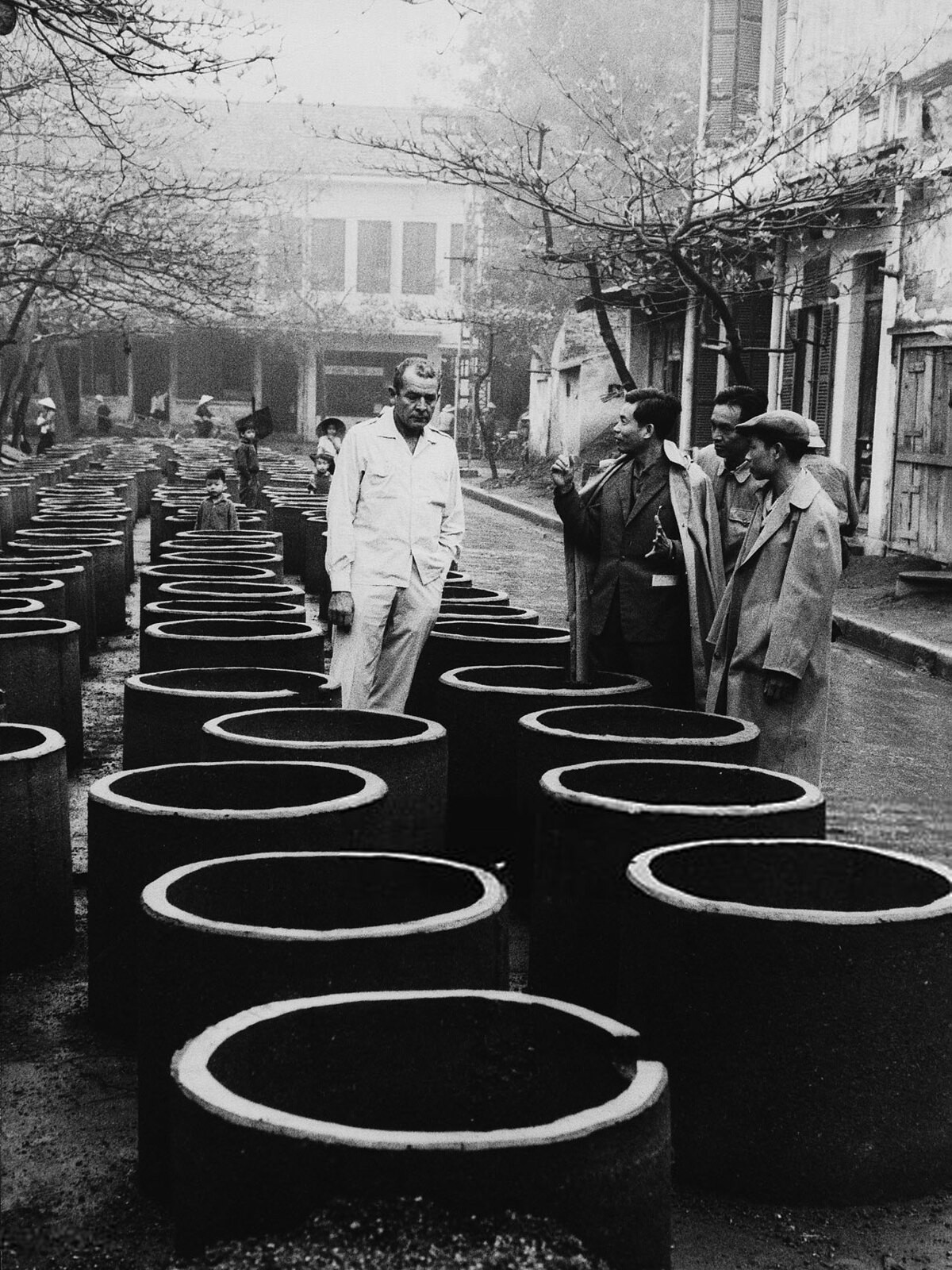 Nhà báo Mỹ Charles Collingwood (1917 - 1985) của hãng CBS News đứng giữa những ống bê tông khi trao đổi với các cán bộ của thành phố Hà Nội, tháng 4/1968. Ảnh: CBS Photo Archive/ Getty.