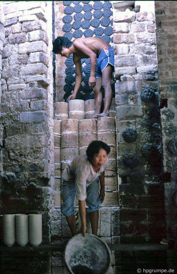 Một lò nung được khởi động: Các thùng chứa sản phẩm đã tạo hình được xếp chồng lên nhau trong lò. Chúng sẽ được nung nóng bằng những bánh than được ốp trên tường. Sau khi chất đủ sản phẩm, lò được đóng. Đồ gốm được nung trong vài ngày trong nhiệt độ khoảng 1250°C.