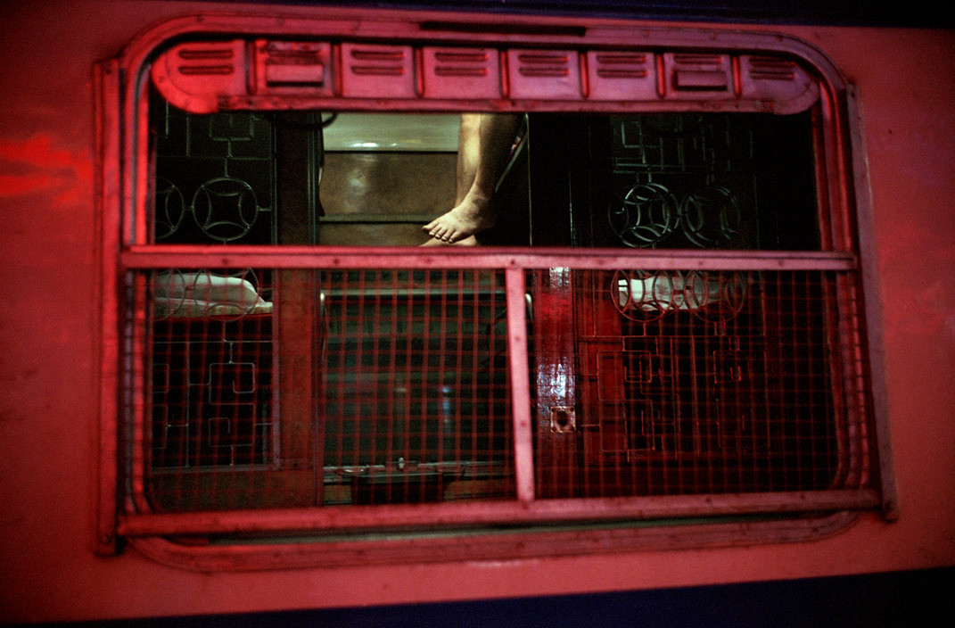 Ô cửa sổ của một toa tàu nhìn từ phía ngoài. Bên trong là khoang giường nằm có nhiều tầng.