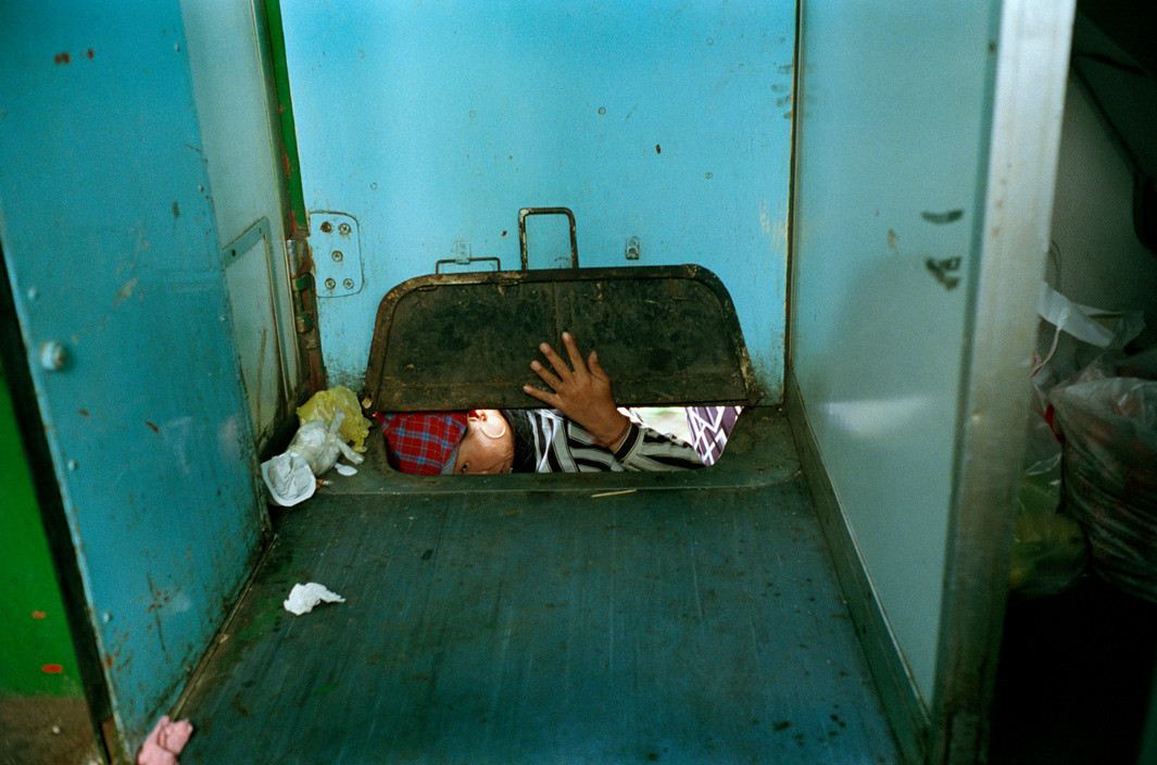 Một số người trốn vé đột nhập vào toa tàu chở hàng hóa qua cánh cửa nhỏ trên sàn tàu, chuyến tàu Huế - hà Nội.