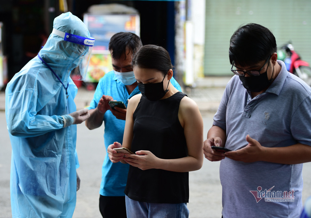 Họ được hướng dẫn dùng điện thoại khai báo y tế trước khi vào tiêm phòng vắc xin