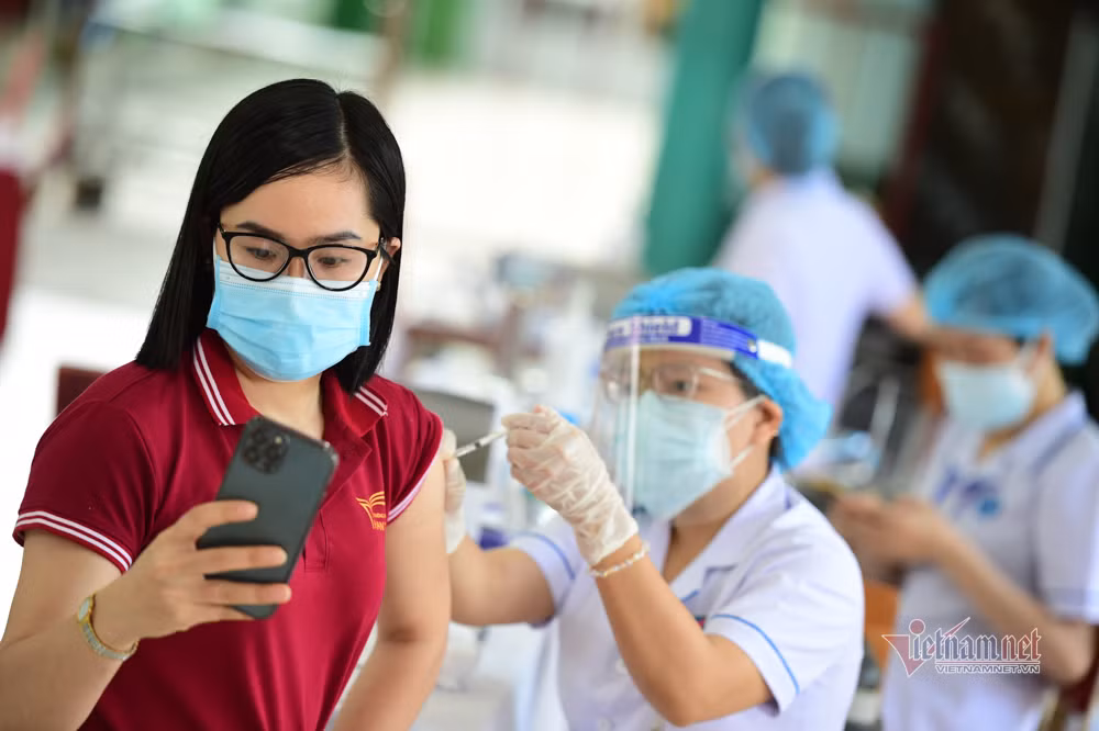 Một cô giáo chụp ảnh, lưu lại kỷ niệm đáng nhớ của mình sau khi tiêm vắc xin