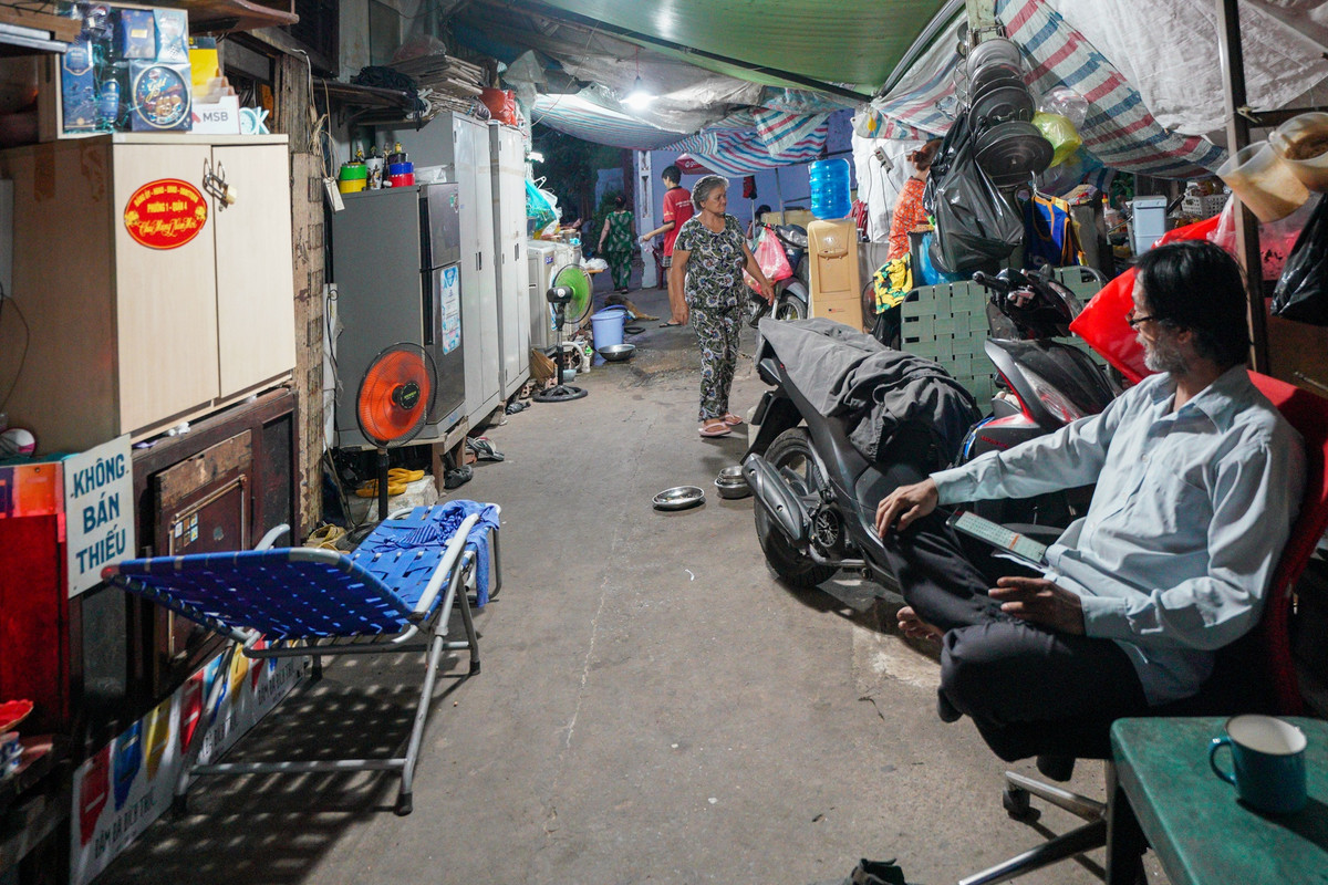 Gia đình của em trai ông Lâm (bên phải) cũng tận dụng lối đi của con hẻm để làm nơi ở tạm. Neo người, nhiều thiếu thốn, song cuộc sống tại hẻm cù lao Nguyễn Kiệu không hề nhàm chán. Phần lớn cư dân đã sống tại đây cả cuộc đời, coi hàng xóm như người thân trong gia đình. Chiều tối, mọi người thường tụ tập ca hát, tám chuyện, đôi khi cũng rủ nhau qua nhà dùng bữa cơm chung.