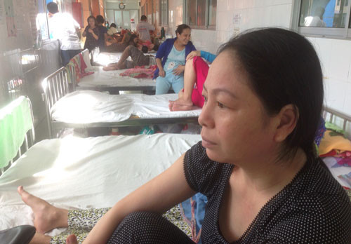 Chị Thủy (áo đen) ngồi chờ trước phòng chuyên sâu sơ sinh để trông chờ tin tức cháu của mình.