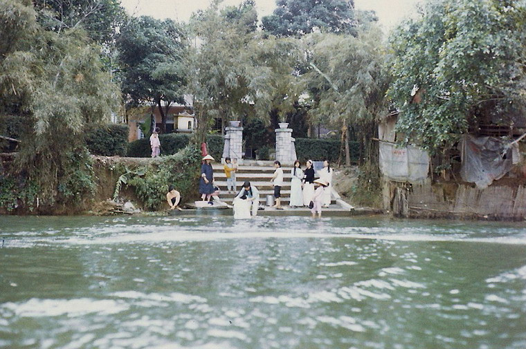 Chị em phụ nữ giặt giũ bên bến sông ở Huế.