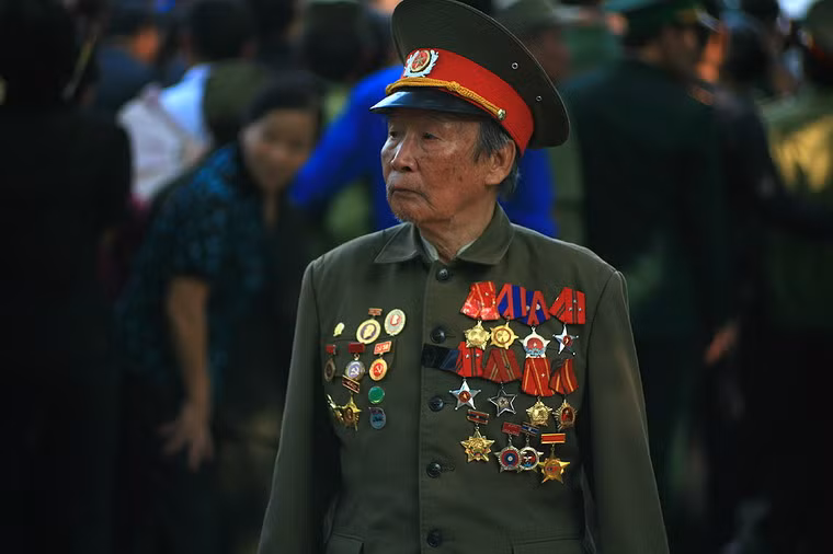 Một cựu chiến binh già đứng tách khỏi dòng người, nhìn xung quanh bằng đôi mắt đượm buồn. Có lẽ ông đang tìm kiếm những đồng đội cũ của mình.