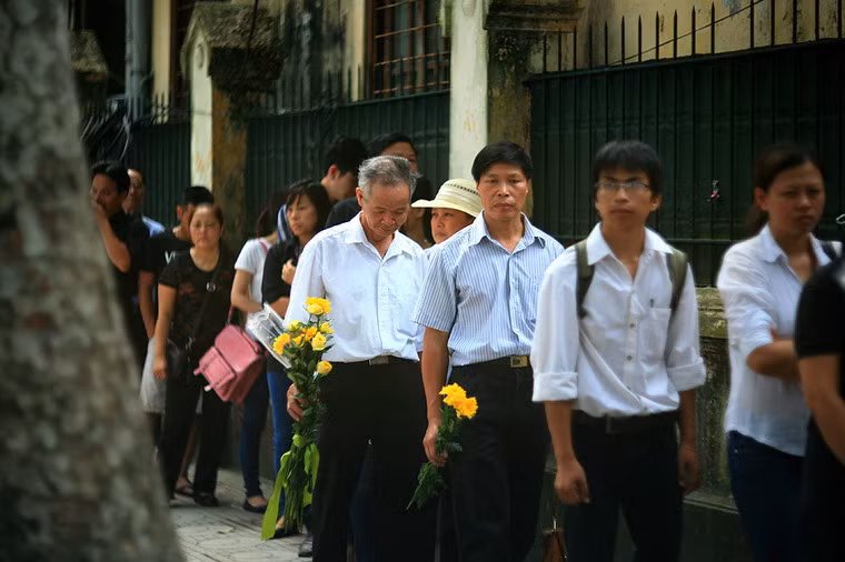 Từng đoàn ngoài lặng lẽ bước về phía ngôi nhà đầy kỷ niệm để tiễn đưa Đại tướng. Nhiều người cầm trên tay những đóa cúc vàng...