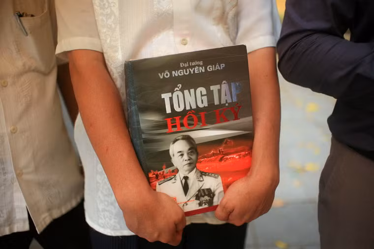 Một số người cầm di ảnh của Đại tướng Võ Nguyên Giáp, hoặc những tác phẩm tâm huyết của ông.