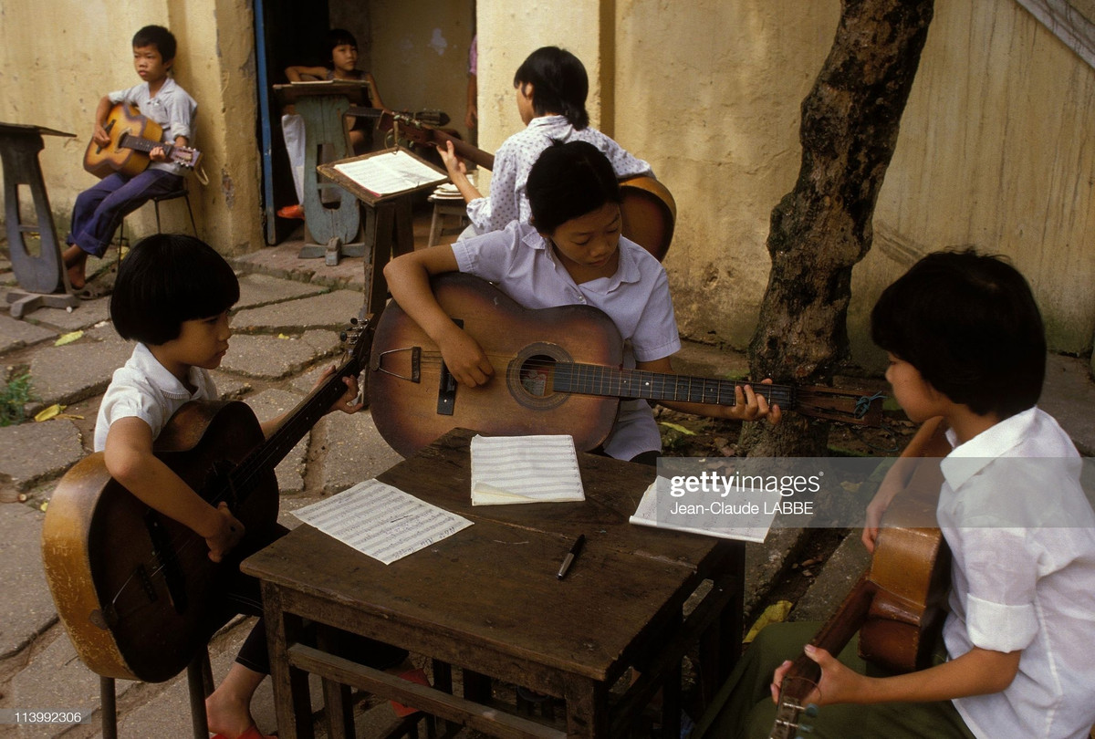 Các bé gái ôm đàn guitar tại một lớp học đàn.