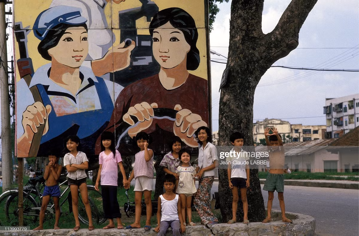 Những đứa trẻ bên một pa-nô tranh cổ động cỡ lớn ở Hà Nội năm 1994. Ảnh: Jean-Claude Labbe/ Getty Images.