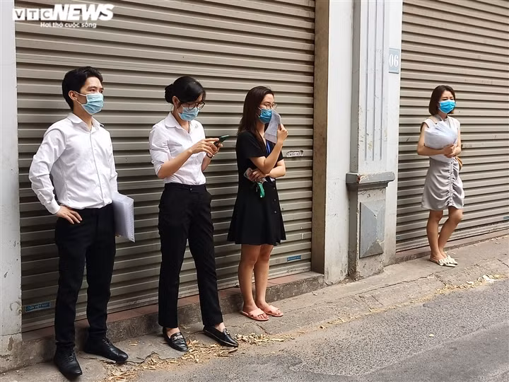 Những người dân tới xin giấy xác nhận đi đường chờ tới lượt.