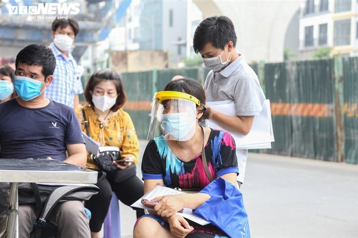 Điều này cũng xảy ra tại UBND phường Minh Khai (quận Hai Bà Trưng). Người dân tập trung, đứng kín khu vực bên ngoài trụ sở, không đảm bảo giữ khoảng cách an toàn.