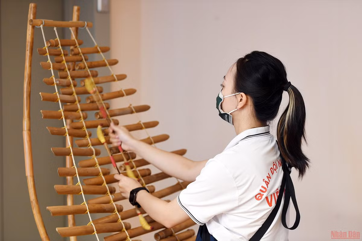 Giang tỉ mỉ chỉnh từng nốt nhạc trên chiếc đàn T'Rưng.