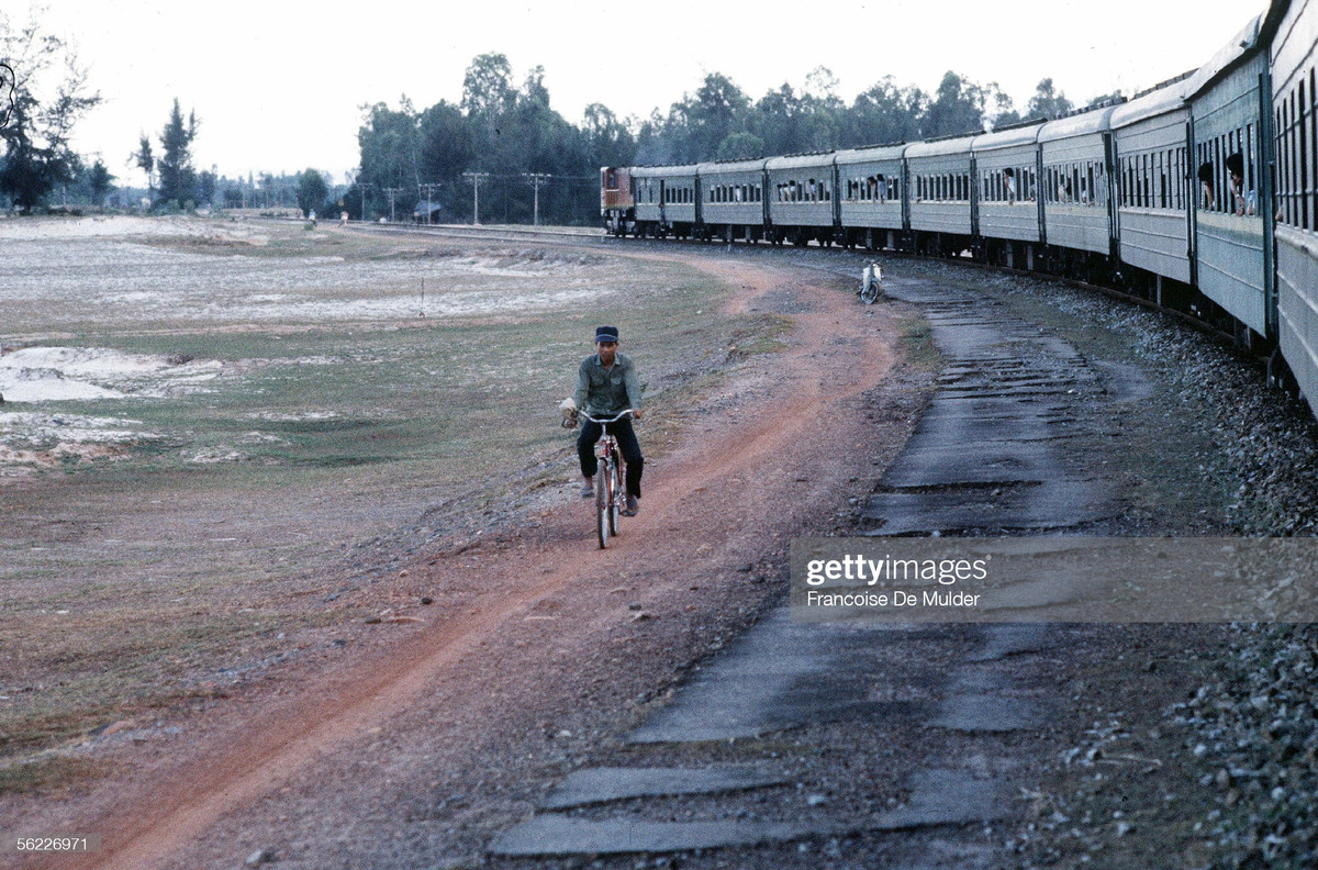 Người đàn ông đạp xe trên con đường đất, nhìn từ cửa sổ toa tàu Bắc - Nam, 1989.