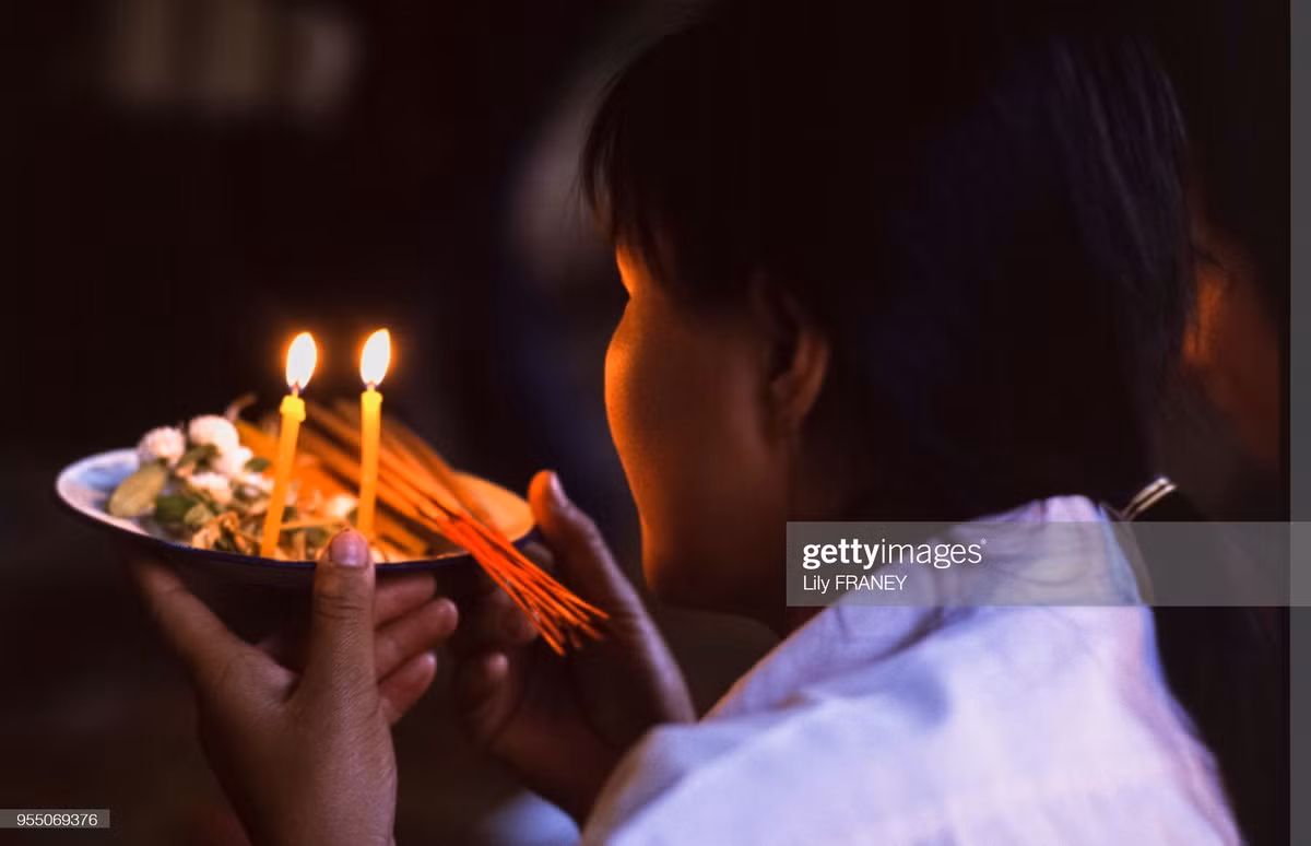 Người phụ nữ dâng lễ vật cho tổ tiên của mình.