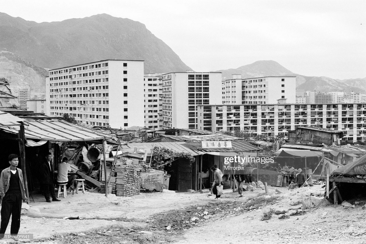 Xóm ổ chuột tồi tàn nằm trên bên những tòa nhà tái định cư đang được hoàn thiện.