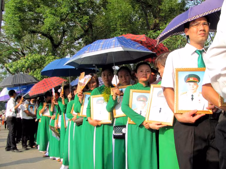 Đoàn cán bộ, công nhân viên Công ty Mai Linh mặc trang phục chỉnh tề, ôm di ảnh Đại tướng đứng xếp hàng.