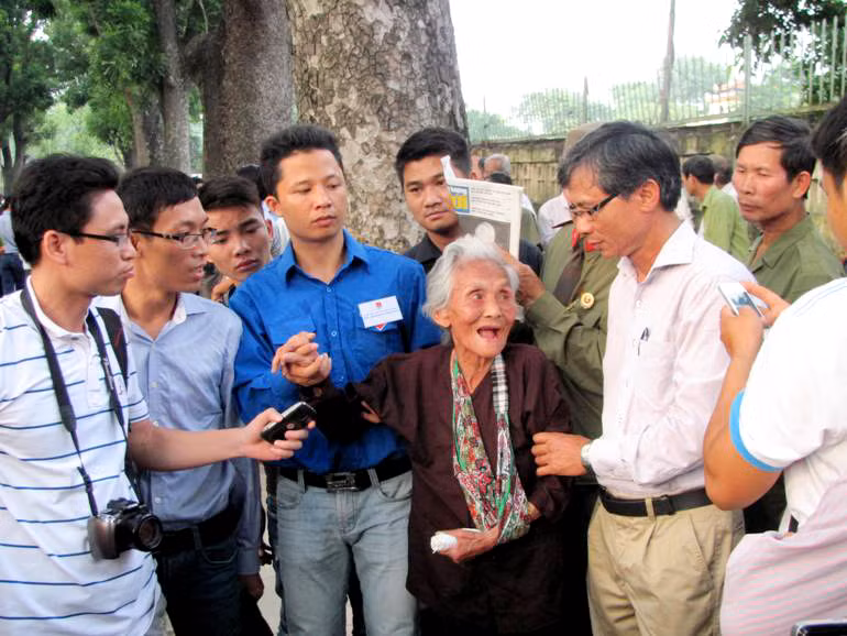 Cụ được lực lượng thanh niên tình nguyện giúp đỡ, nhiều người xúc động vây quanh cụ thăm hỏi.