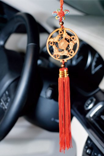 Tua rua phong thủy: Người phương Đông quan niệm rằng những sợi dây tua rua màu đỏ này sẽ thu hút sự may mắn cũng như những niềm vui trong cuộc sống về phía bạn. Tua rua phong thủy có thể được tết kiểu đơn giản hoặc gắn vào một phù điêu. Như hình bên, tua rua được gắn vào một phù điêu kỳ lân bằng gỗ: kỳ lân là biểu tượng sức mạnh bảo vệ bạn khỏi những điều có hại, gỗ bổ sung thêm hành Mộc trong xe và những sợi dây màu đỏ mang lại may mắn.