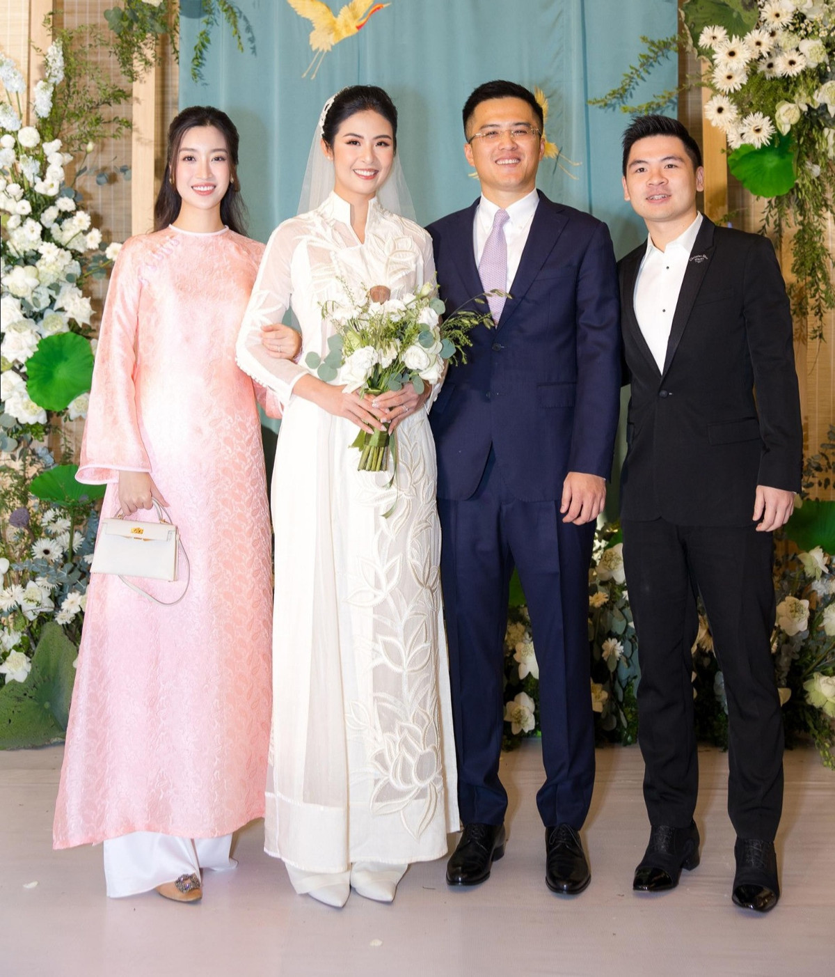 Người đẹp gốc Hà Thành và chồng xuất hiện trong đám cưới hoa hậu Ngọc Hân. Cô diện áo dài cách tân dáng suông để lộ vòng 2 kém thon gọn.