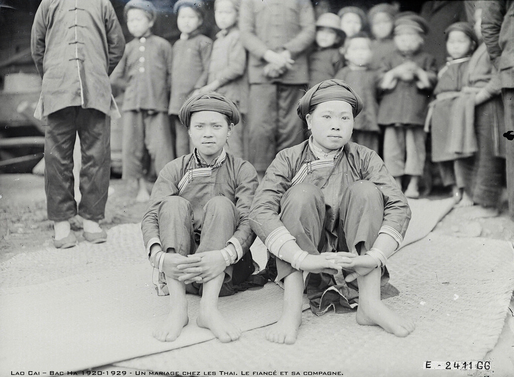 Cô dâu cũng còn rất nhỏ tuổi, ngồi bên người bạn của mình.