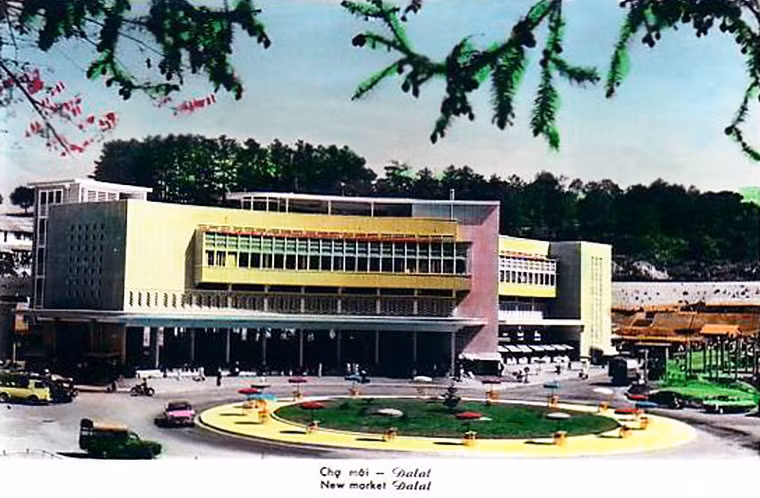 Chợ Đà Lạt trong một bưu thiếp tô màu in năm 1962. Sau khi chợ được xây, kiến trúc sư Ngô Viết Thụ đã tham gia chỉnh trang chợ ở các hạng mục mặt tiền, cầu nổi bê tông, khu công viên trước chợ, và các dãy phố lầu xung quanh chợ.