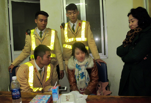 Cô gái (ngồi giữa) được các chiến sĩ CSGT Đội số 1 đưa về trụ sở.