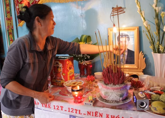 Mẹ của anh Mai Hữu Tôn nghẹn ngào bên di ảnh đứa con trai duy nhất của mình.