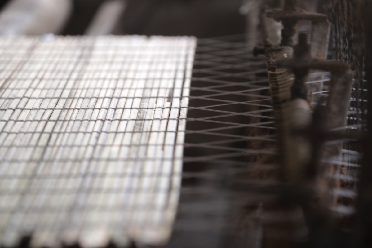 Một tấm mành cọ dần hình thành trên máy dệt, dưới bàn tay thao tác của người làm cọ Quảng Yên.