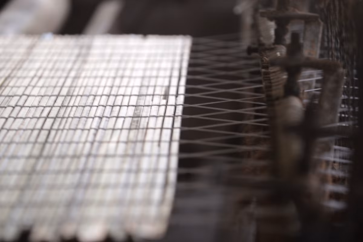 Một tấm mành cọ dần hình thành trên máy dệt, dưới bàn tay thao tác của người làm cọ Quảng Yên.