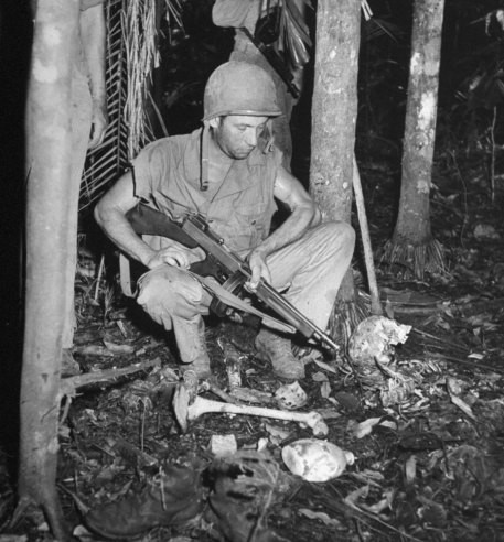 Một binh sĩ Mỹ quan sát xương sườn, hộp sọ... của những người chết trong khu rừng thuộc Guadalcanal năm 1942.